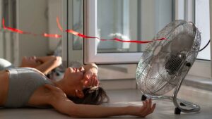 femme se refroidissant devant un ventilateur