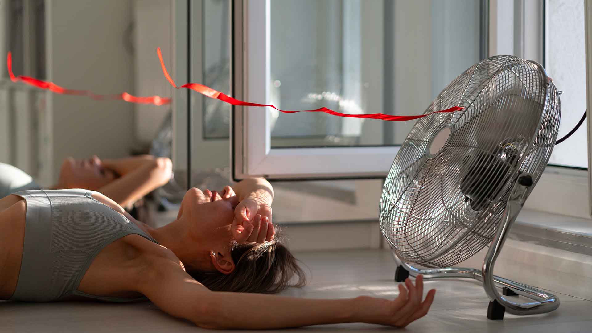 femme se refroidissant devant un ventilateur